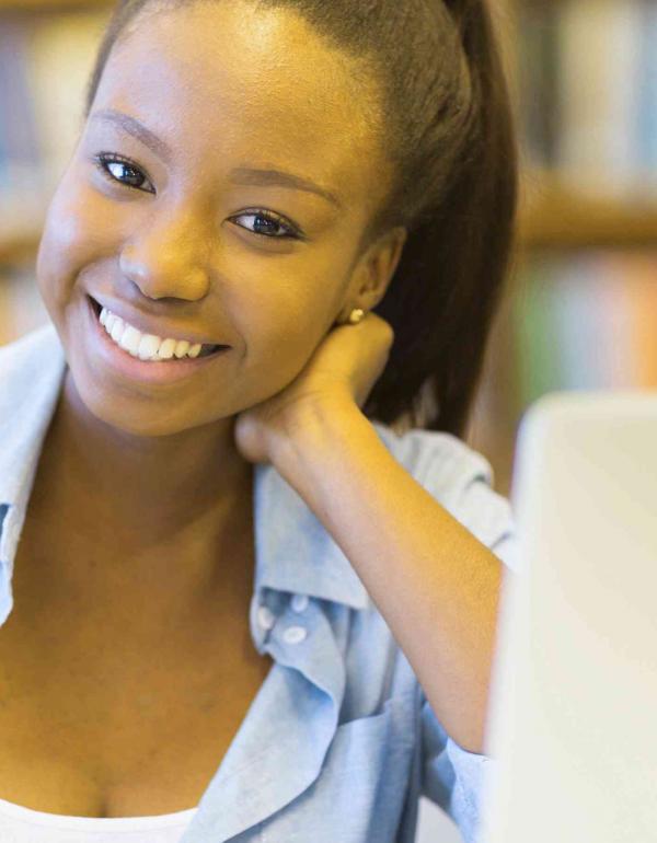 Young African-American female smiling in front of a laptop