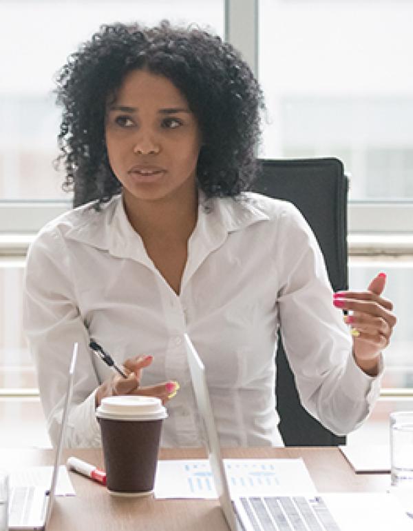 Young African-American female smiling in front of a laptop