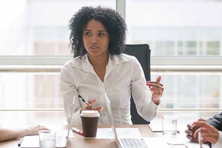 Young African-American female smiling in front of a laptop