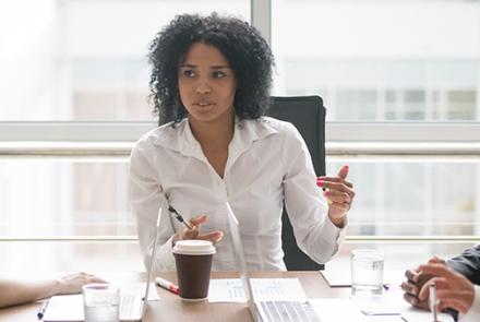 Young African-American female smiling in front of a laptop
